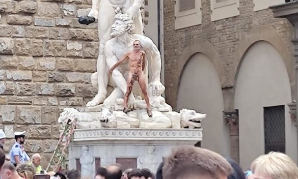 Nudo arrampicarsi su statua a Firenze piazza Signoria