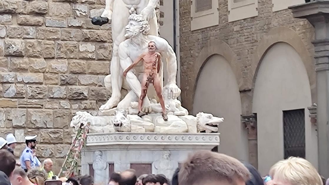 Nudo arrampicarsi su statua a Firenze piazza Signoria