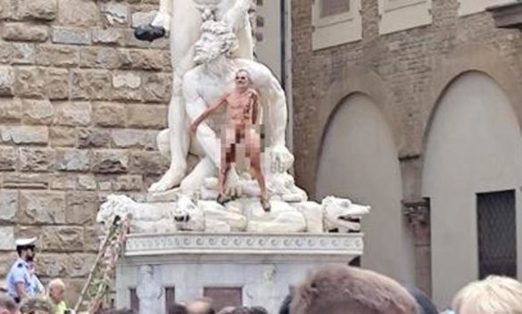 Nudo con scritta 'censurato', uomo si arrampica su statua a Firenze