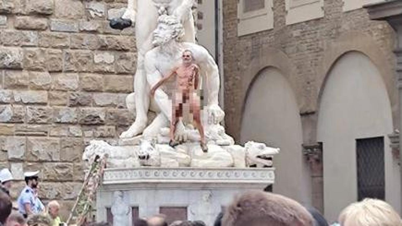 Nudo con scritta 'censurato', uomo si arrampica su statua a Firenze