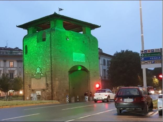 Settimana internazionale malattie mitocondriali, porte storiche illuminate di verde.