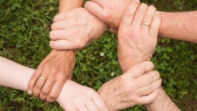 6 mani che si stringono in cerchio, prendendosi per i polsi